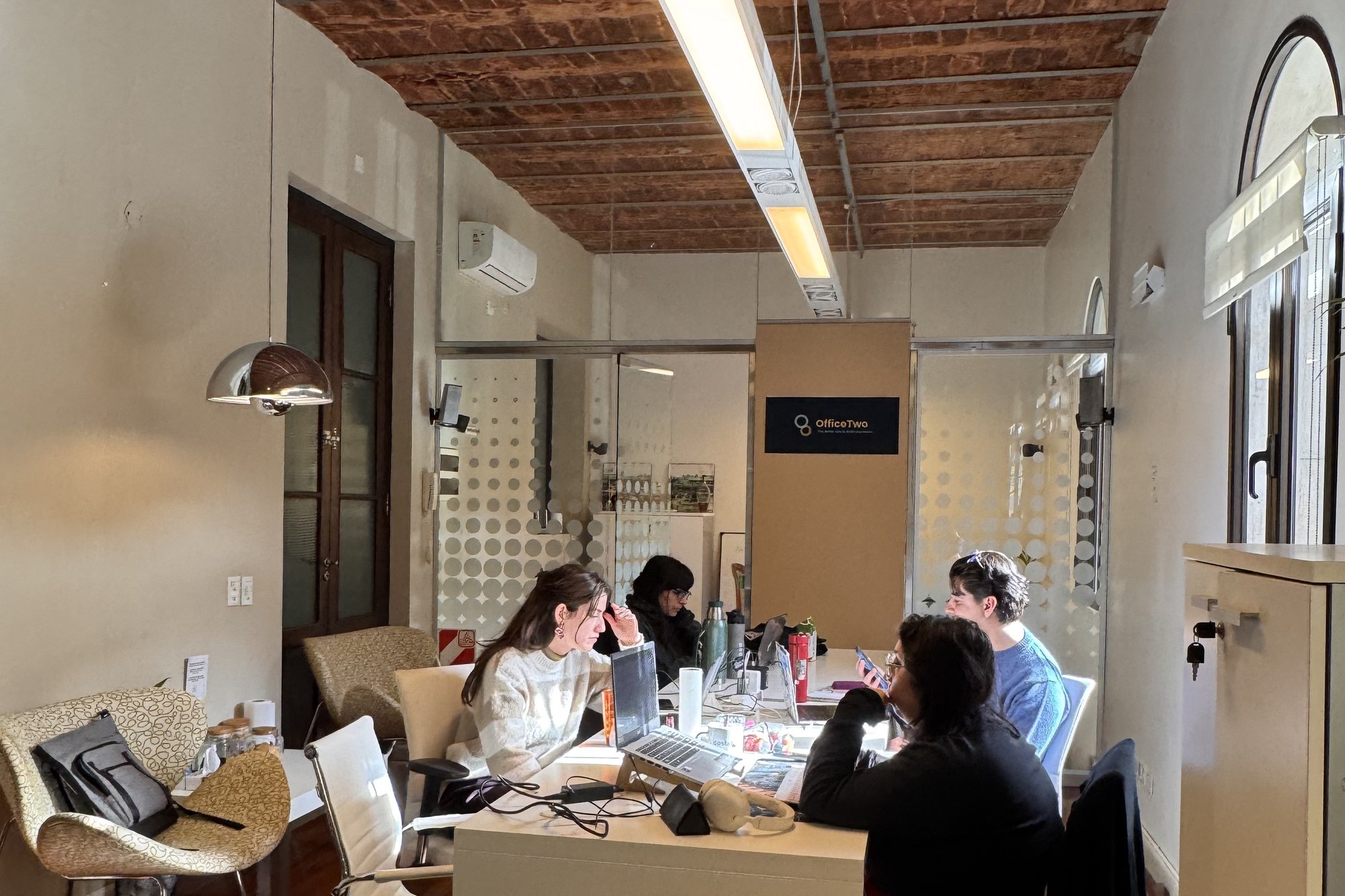 People at work at the long white desk in the Buenos Aires office